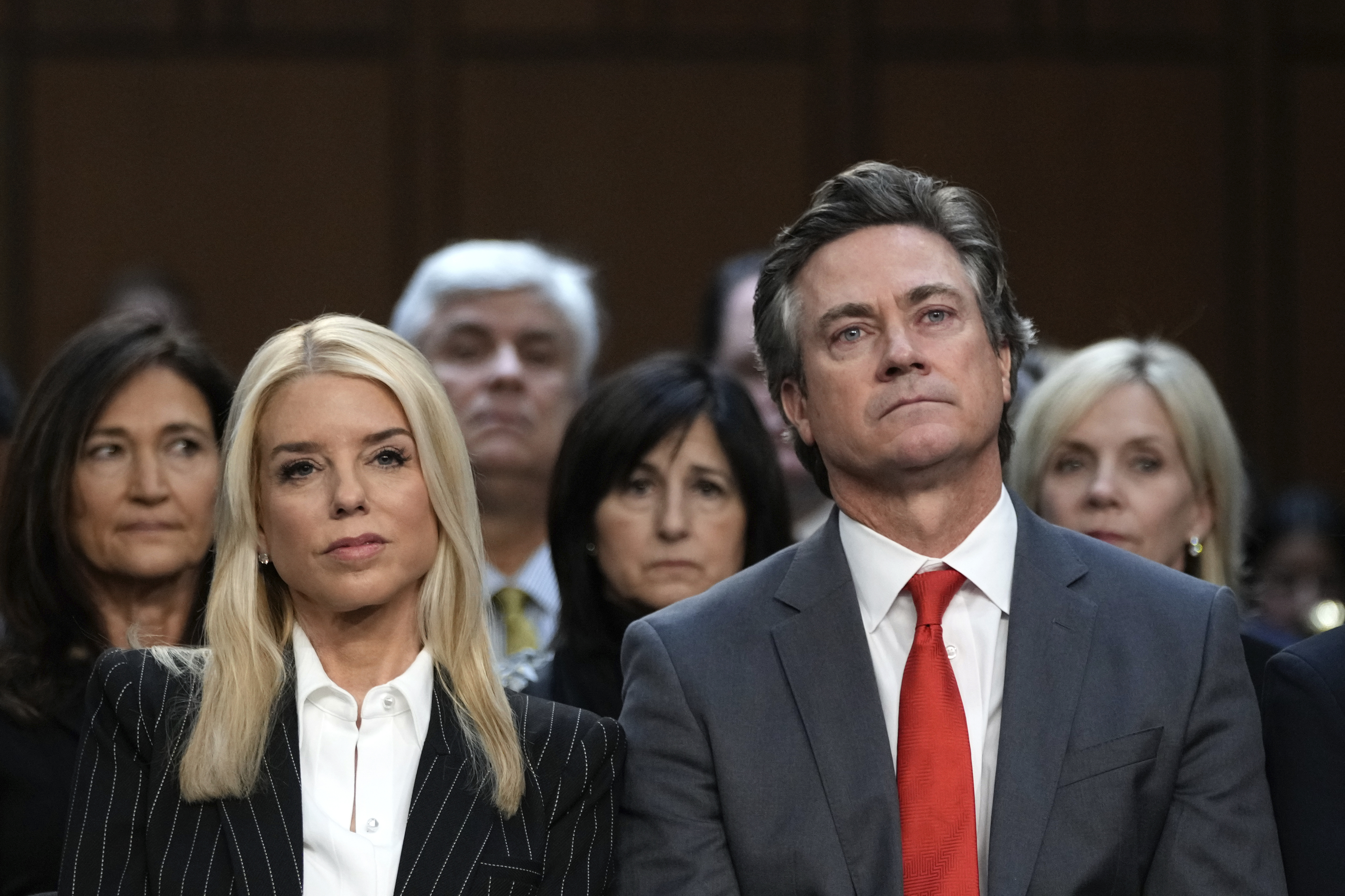 Pam Bondi, President-elect Donald Trump's choice to lead the Justice Department as attorney general, and her husband John Wakefield listen during the Senate Judiciary Committee for her confirmation hearing, at the Capitol in Washington, Wednesday, Jan. 15, 2025. (AP Photo/Ben Curtis)