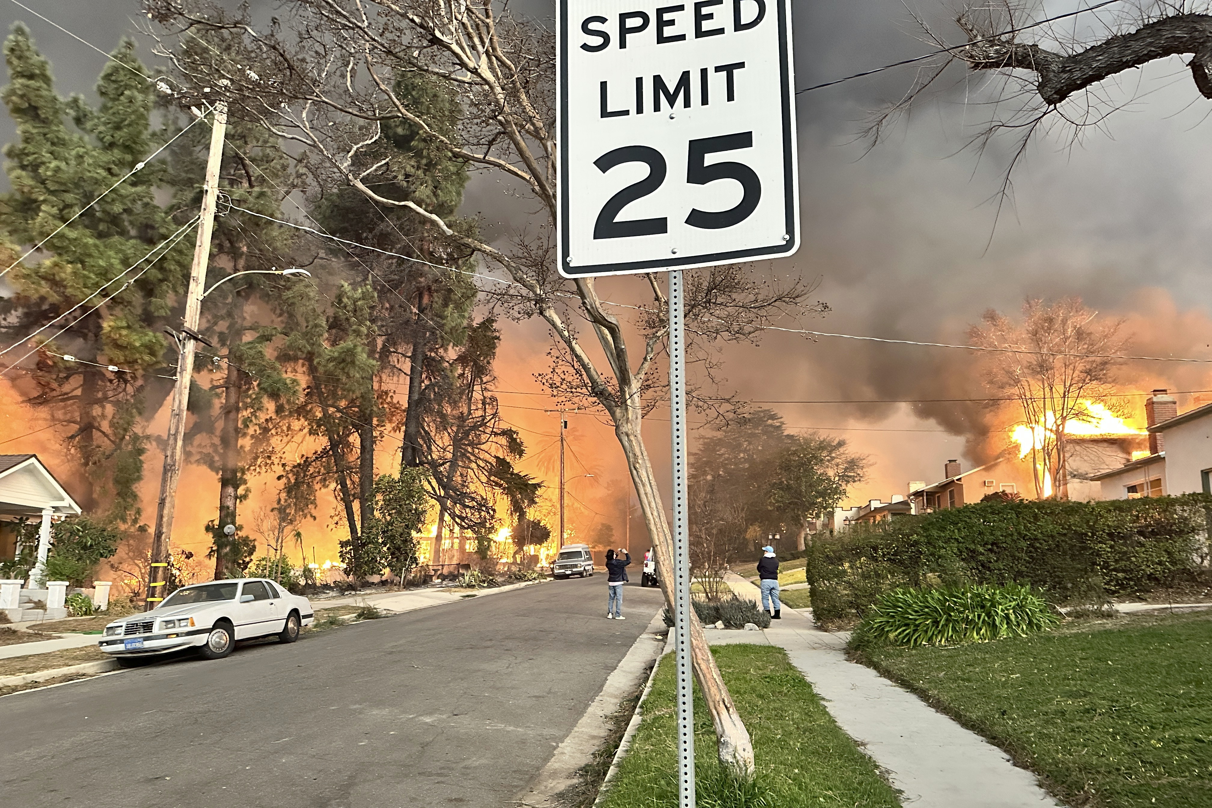 The Eaton Fire burns homes as Ryan Pearson, a Los Angeles-based entertainment video editor for The Associated Press, drives through his neighborhood in Altadena, Calif., Wednesday, Jan. 8, 2025. (AP Photo/Ryan Pearson)