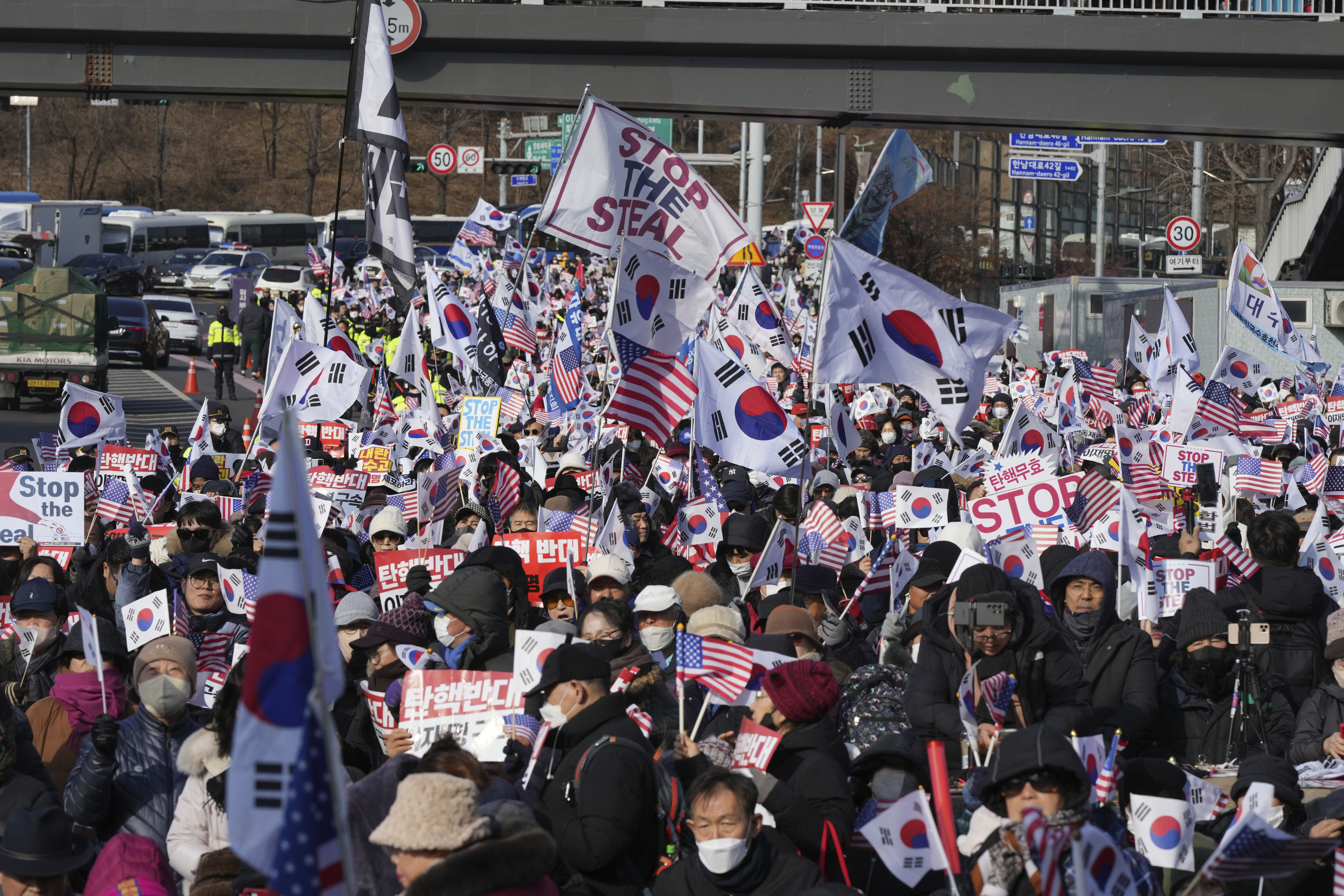 FILE - Supporters of impeached South Korean President Yoon Suk Yeol stage a rally to oppose a court having issued a warrant to detain Yoon, near the presidential residence in Seoul, South Korea, Jan. 3, 2025. The letters read, "Oppose Impeachment." (AP Photo/Lee Jin-man, File)