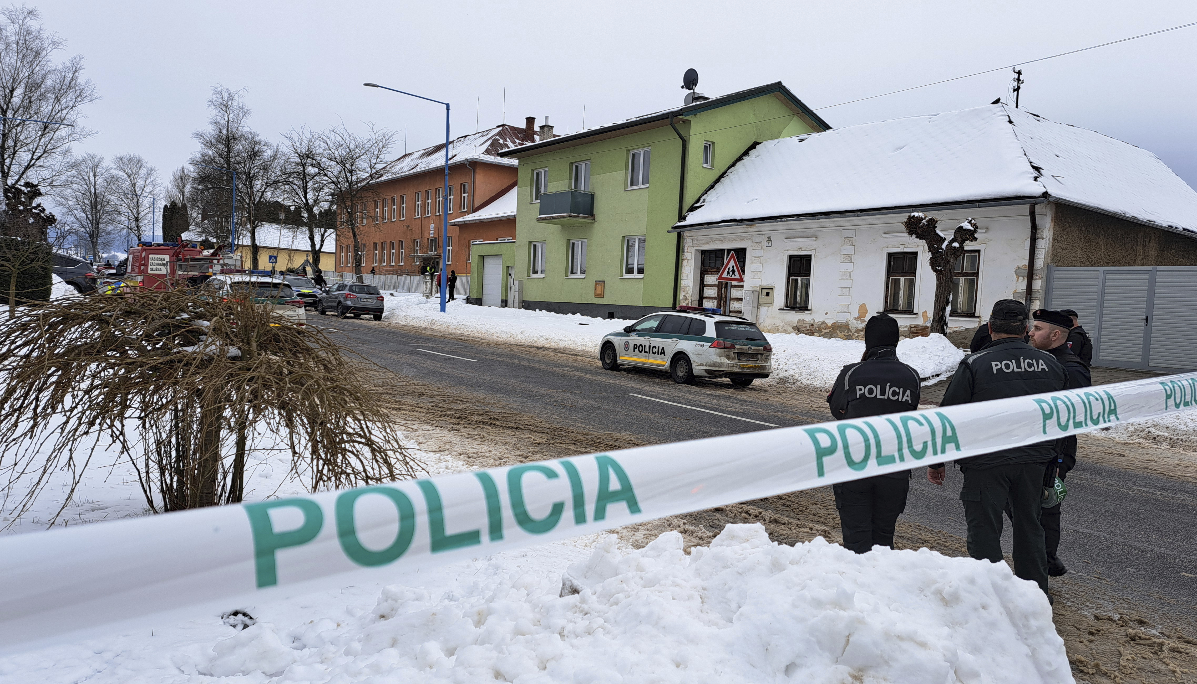 Police guard near the scene where two people were fatally stabbed at a secondary grammar school, center left, in the town of Spisska Stara Ves (Presov region), eastern Slovakia, Thursday, Jan. 16, 2025. (Adriana Hudecova/TASR via AP)