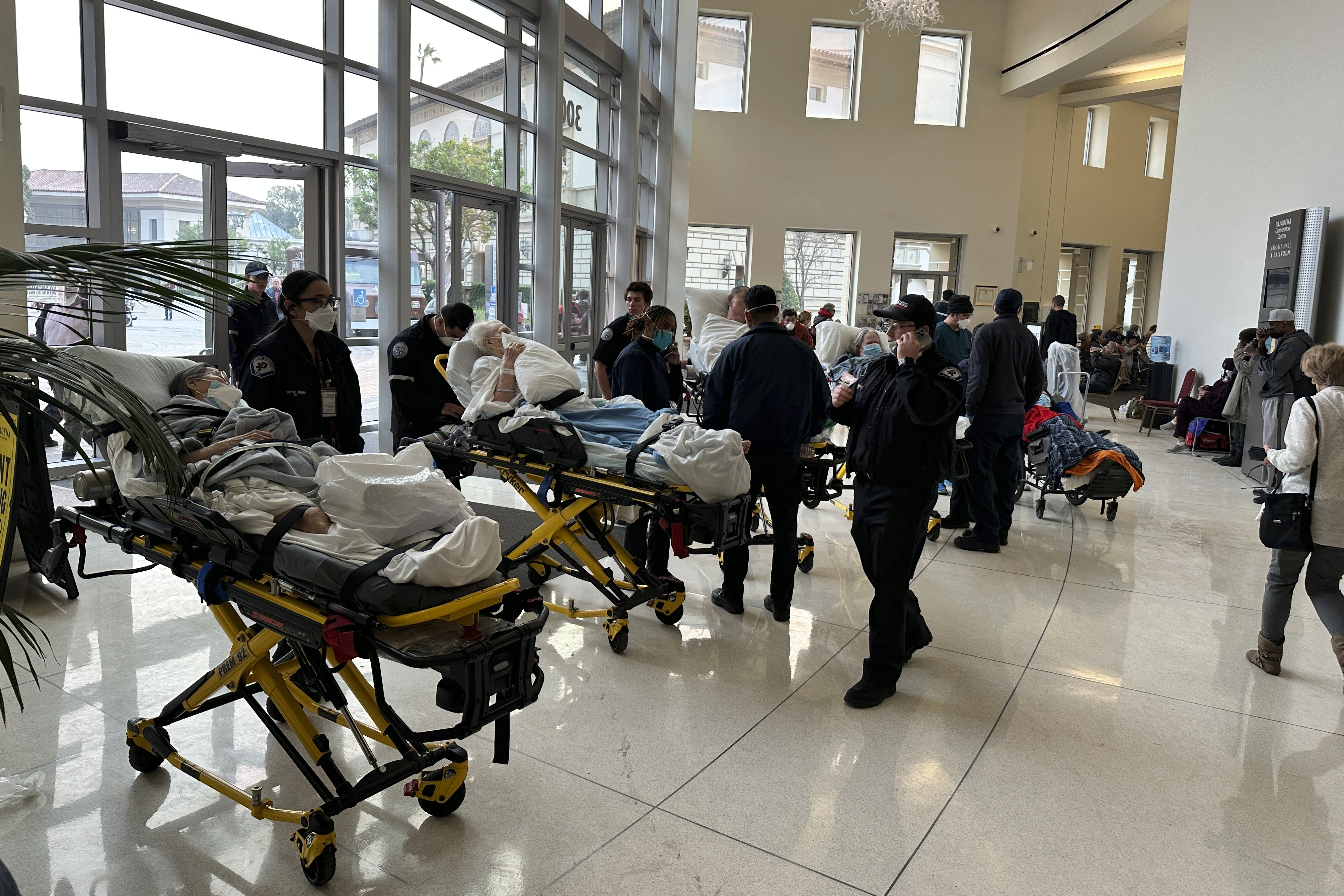 People are wheeled into an evacuation center at the Pasadena Convention Center in Pasadena, Calif., as they are evacuated due to the Eaton Fire, Wednesday, Jan. 8, 2025. (AP Photo/Ryan Pearson)