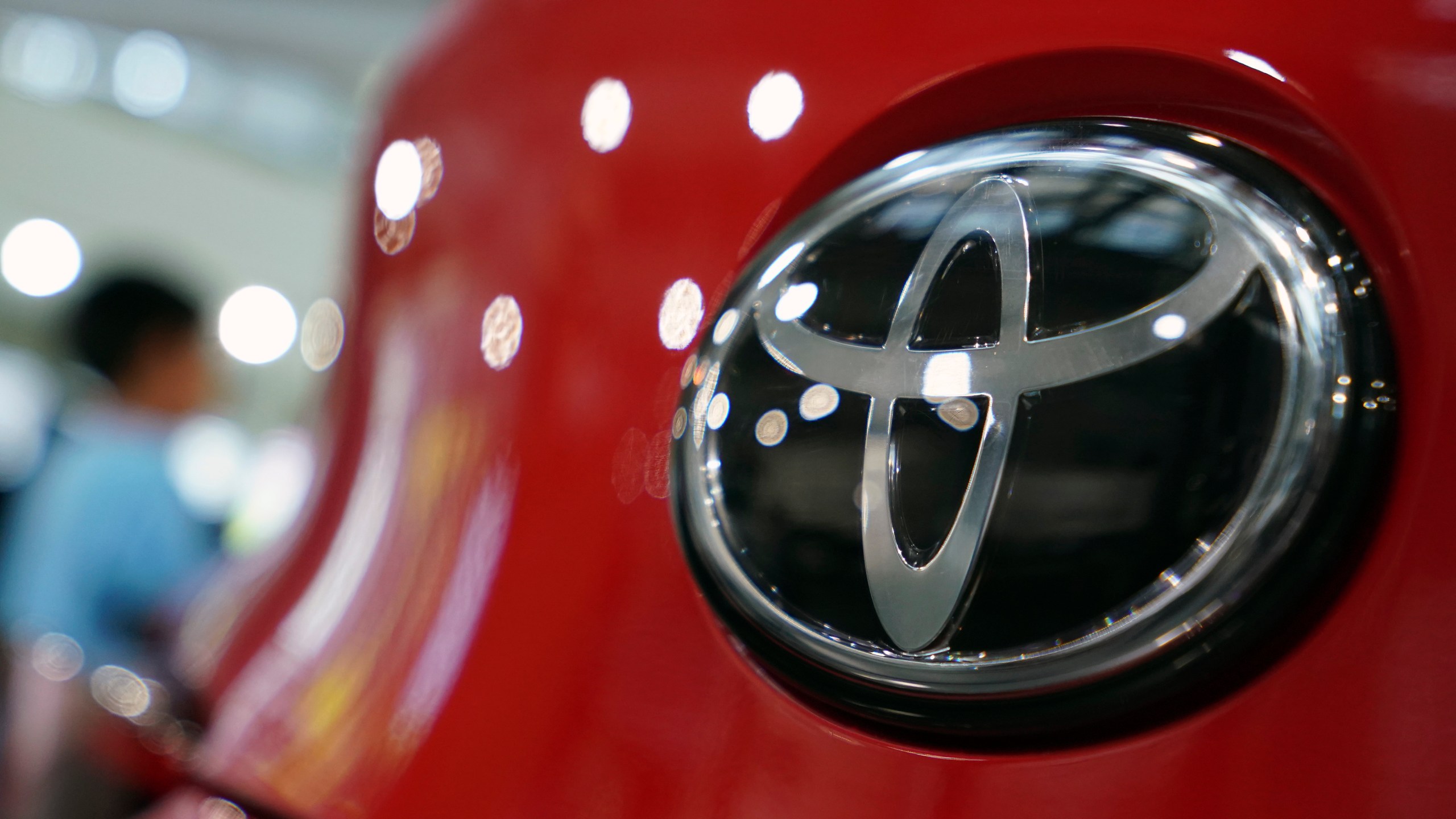 FILE - In this Aug. 2, 2019, file, photo, people walk by the logo of Toyota at a show room in Tokyo. (AP Photo/Eugene Hoshiko, File)