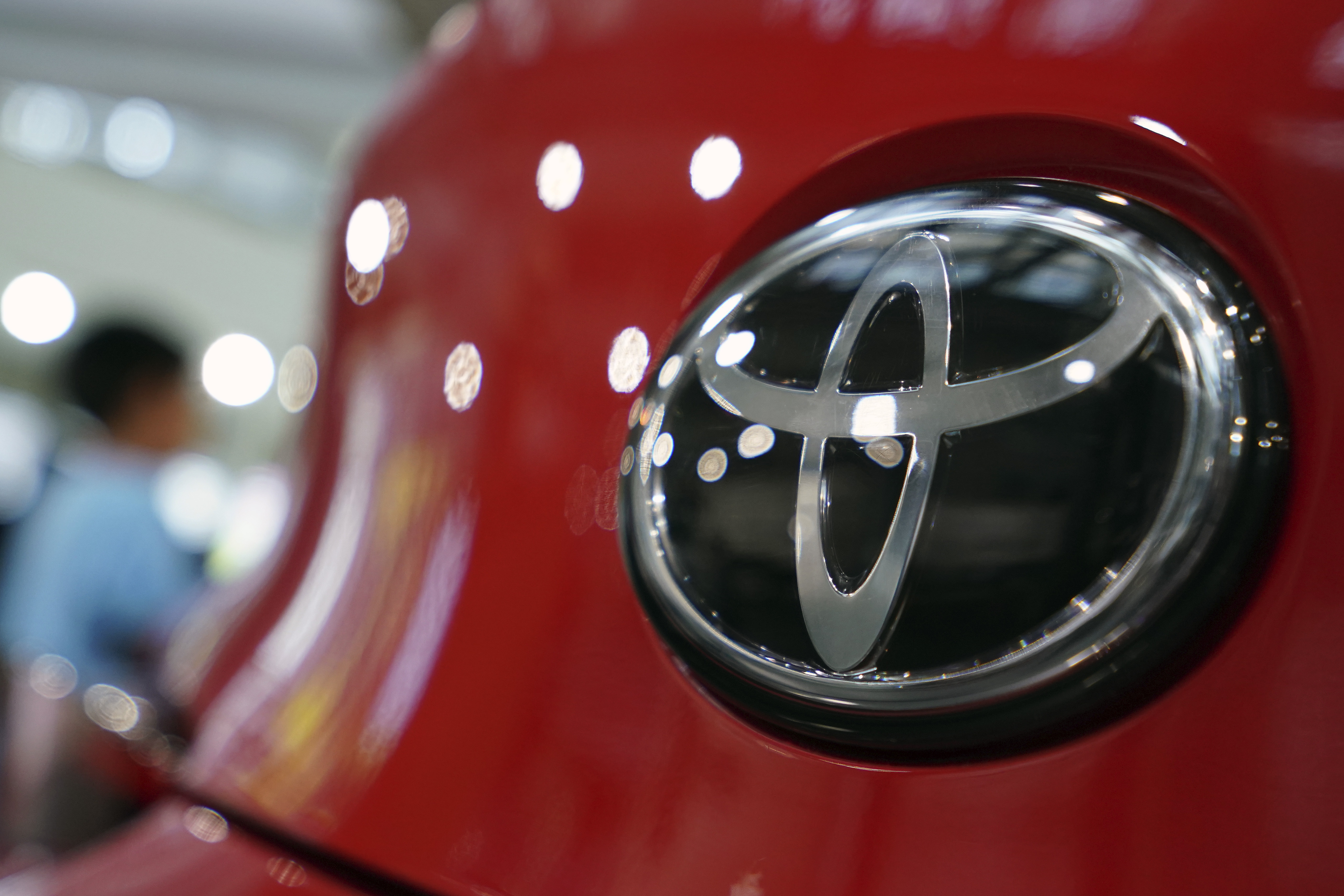 FILE - In this Aug. 2, 2019, file, photo, people walk by the logo of Toyota at a show room in Tokyo. (AP Photo/Eugene Hoshiko, File)