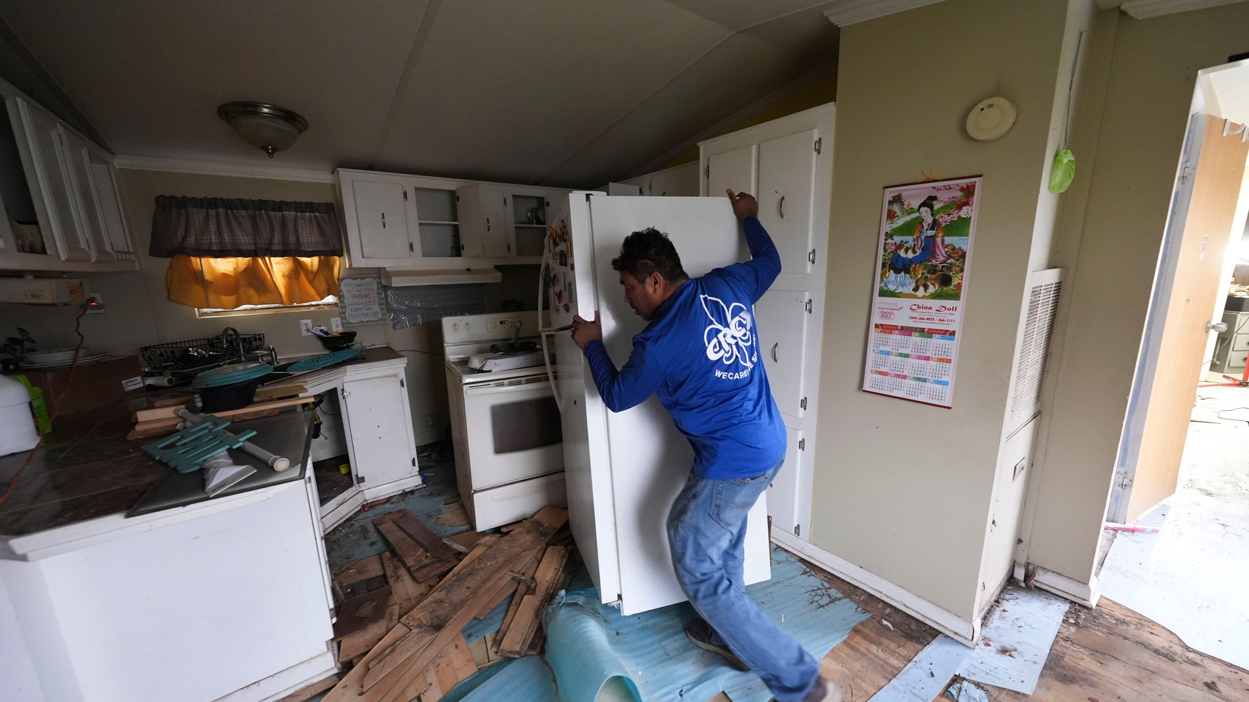 Mario Mendoza works on repairing a mobile home in Belle Chasse, La., Wednesday, Jan. 15, 2025, that was damaged from Hurricane Ida in 2021. (AP Photo/Gerald Herbert)