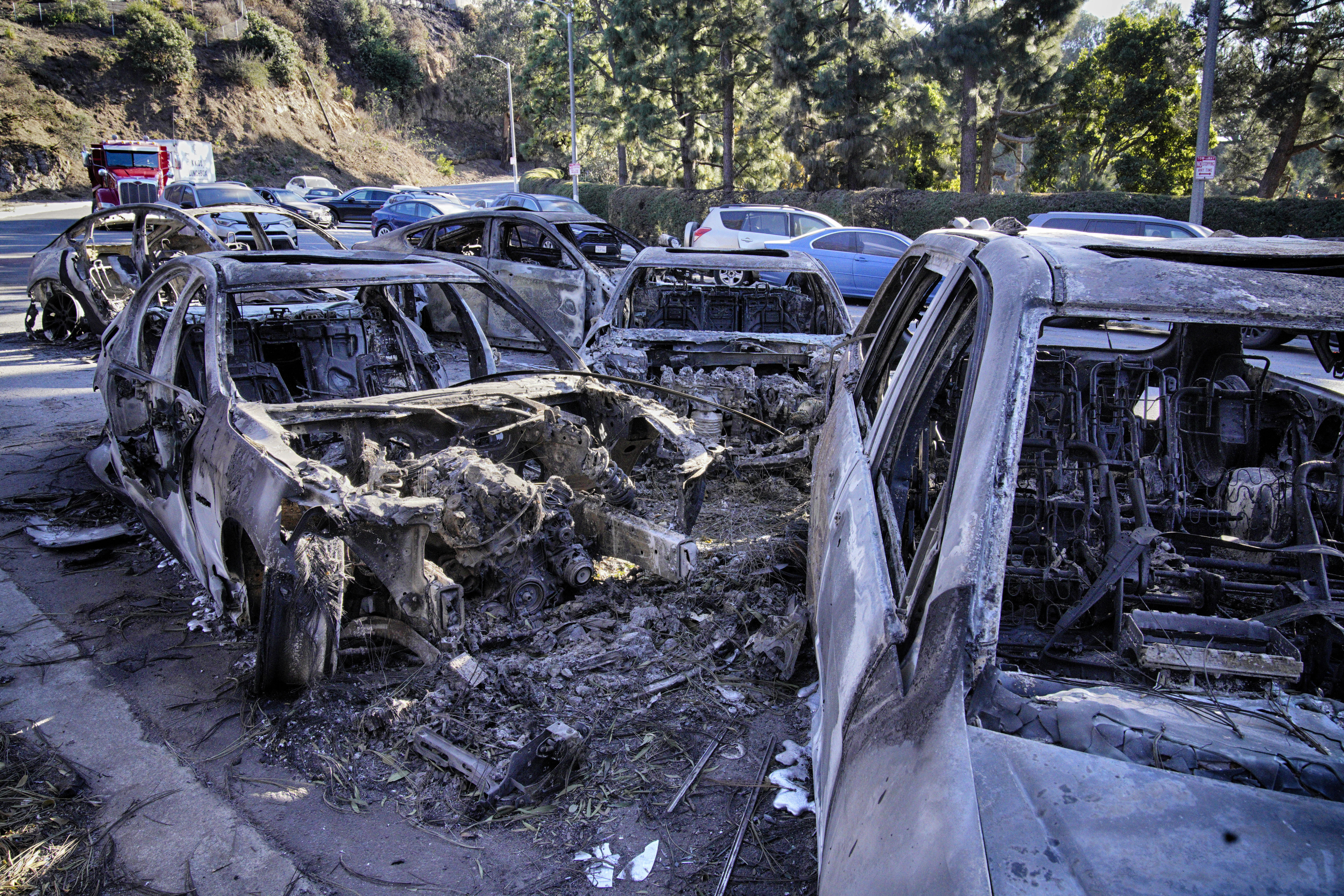 Destroyed and melted cars sit left along Sunset Blvd. after the wildfire that spread through the Pacific Palisades neighborhood of Los Angeles, Wednesday, Jan. 15, 2025. (AP Photo/Richard Vogel)