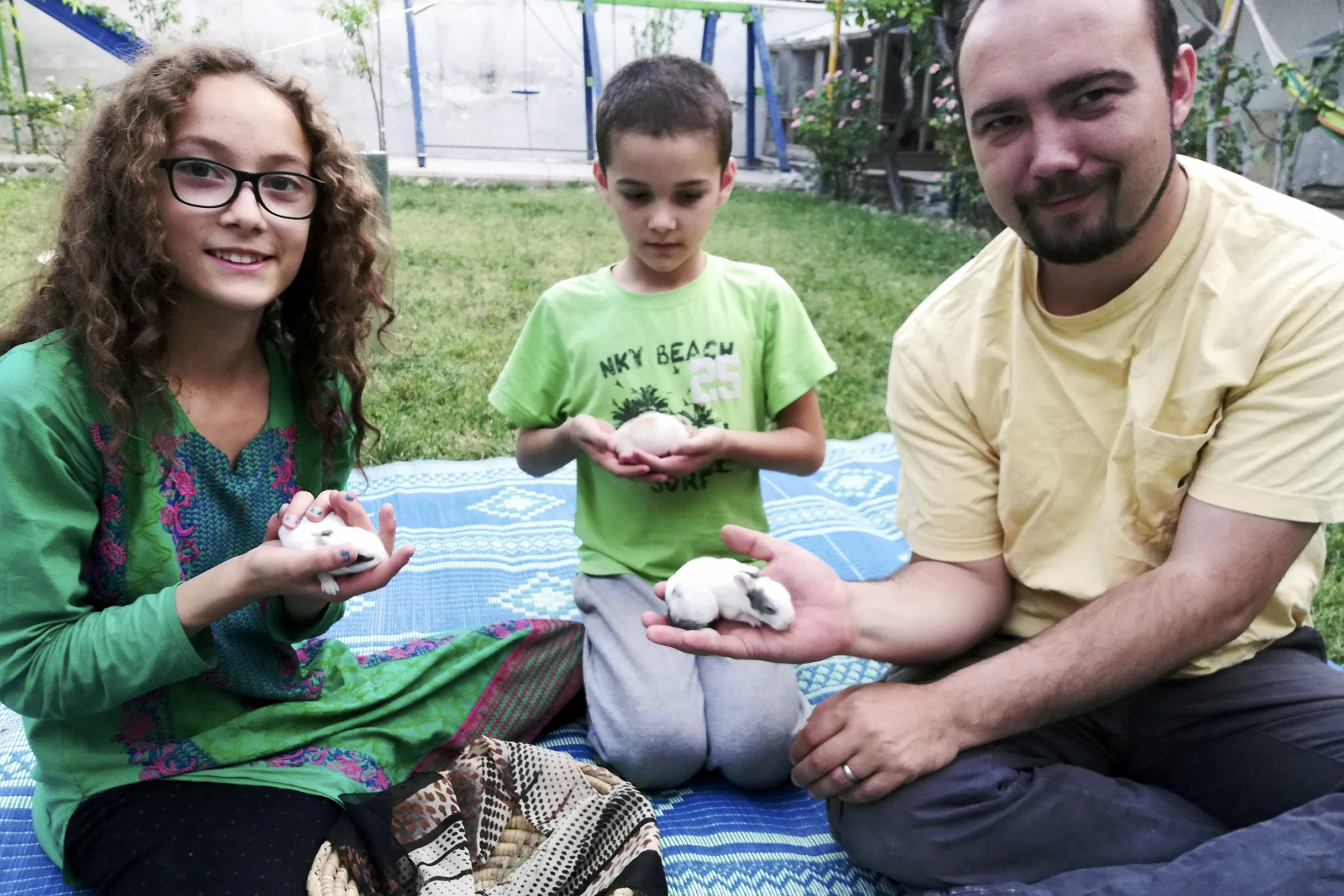 This family photo shows Ryan Corbett holding rabbits with his daughter Miriam and son Caleb in Kabul, Afghanistan in 2020. (Anna Corbett via AP)