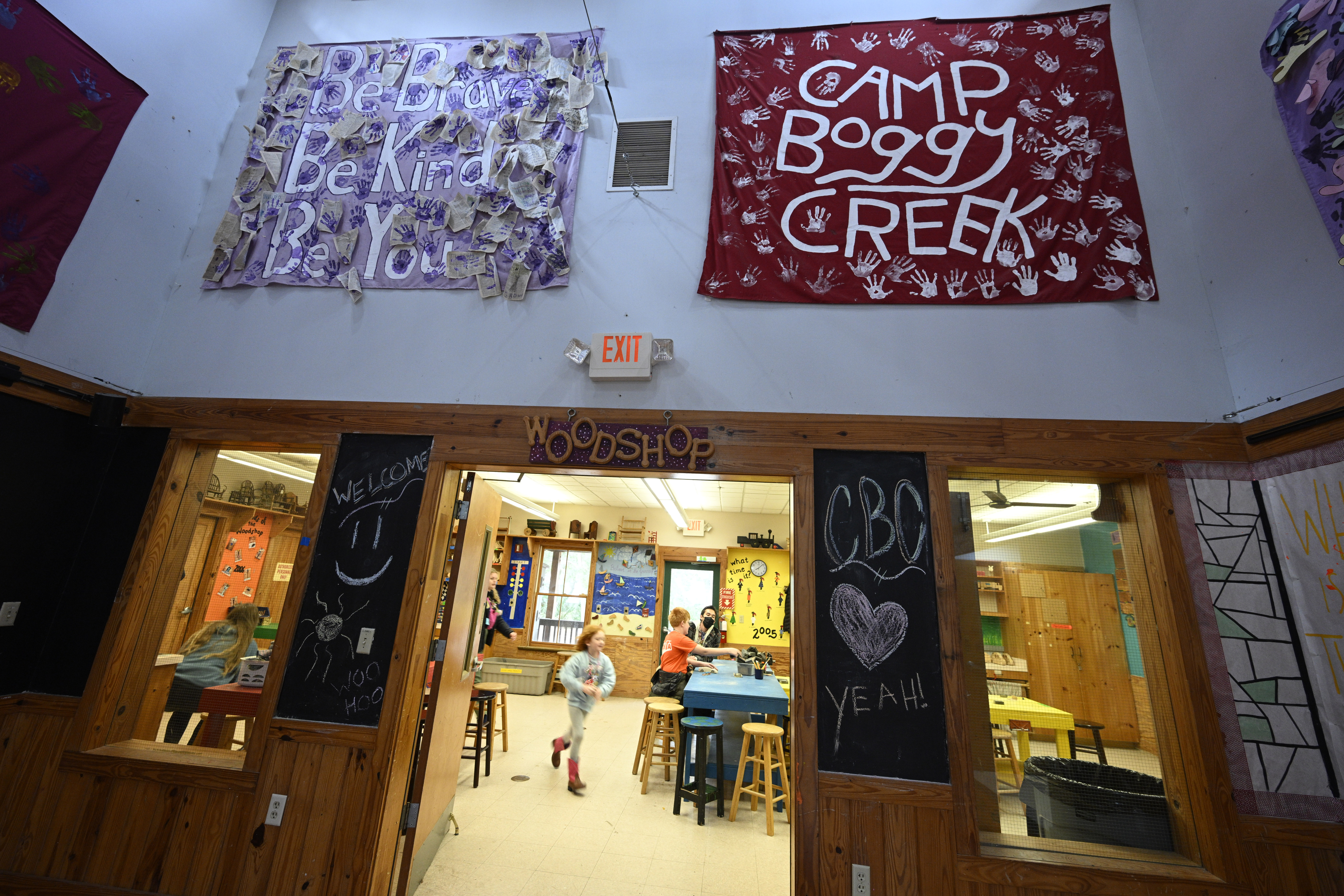 Volunteer counselors help children inside the workshop at Camp Boggy Creek, where children with serious illnesses and their families are provided with a free camp experience, Saturday, Jan. 11, 2025, in Eustis, Fla. (AP Photo/Phelan M. Ebenhack)