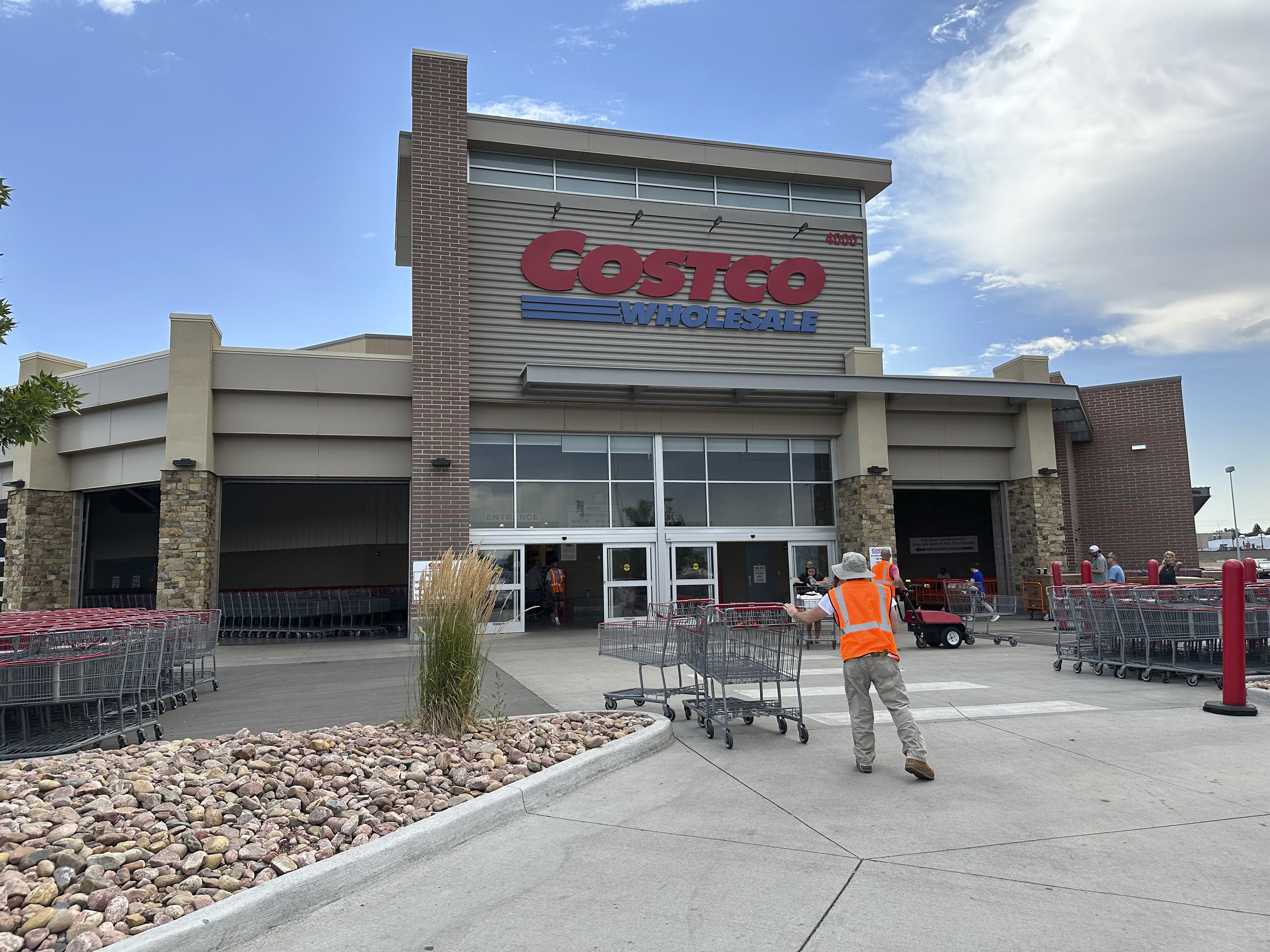 FILE - A cart wrangler gathers shopping carts outside a Costco warehouse in Sheridan, Colo., July 16, 2024. (AP Photo/David Zalubowski, File)