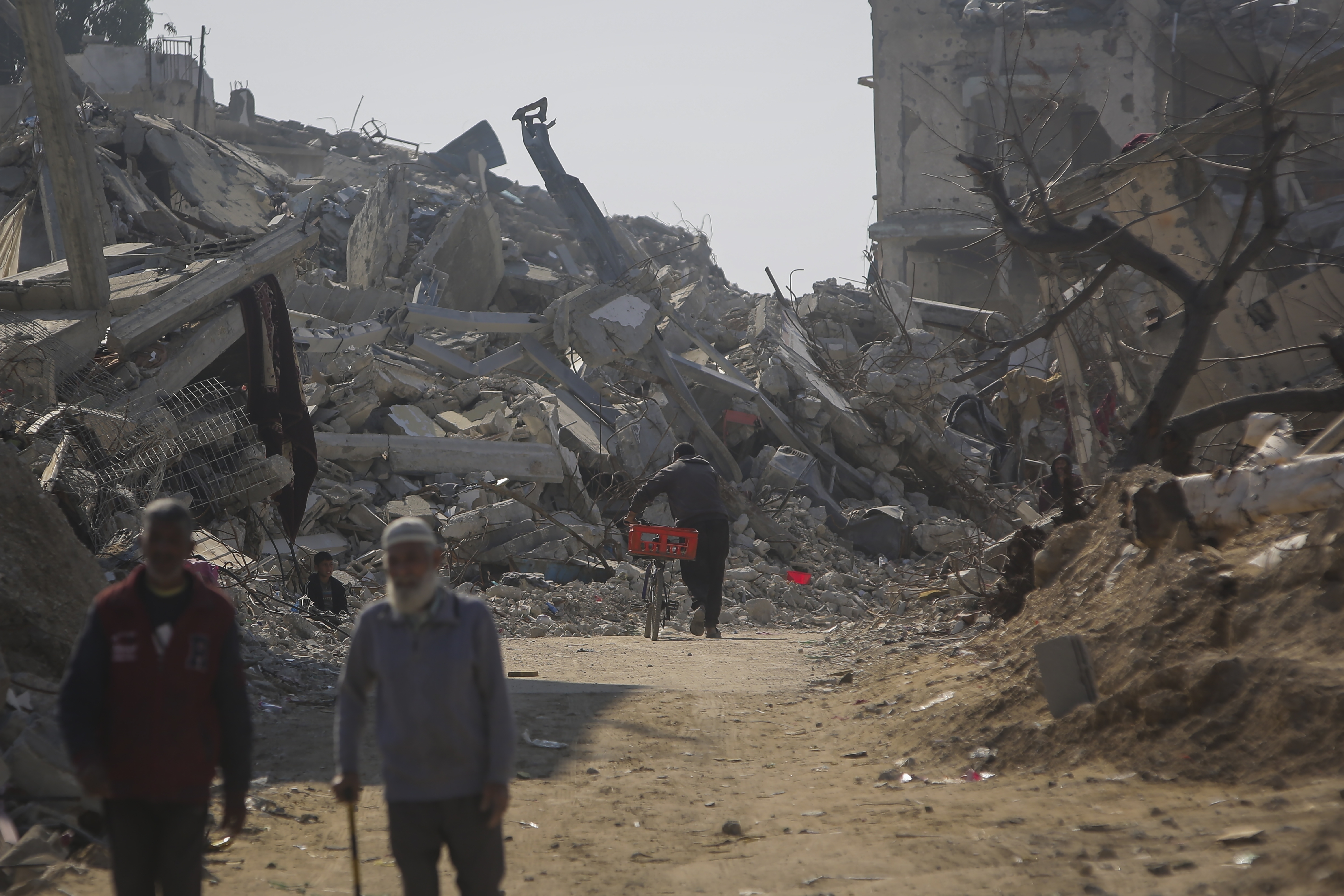 A man pushes his bicycle among the rubble of buildings largely destroyed by Israeli army bombardments in Beit Lahia, northern Gaza Strip, Wednesday, Jan. 29, 2025, after Israel began allowing hundreds of thousands of Palestinians to return to the heavily damaged area last Monday.(AP Photo/Jehad Alshrafi)