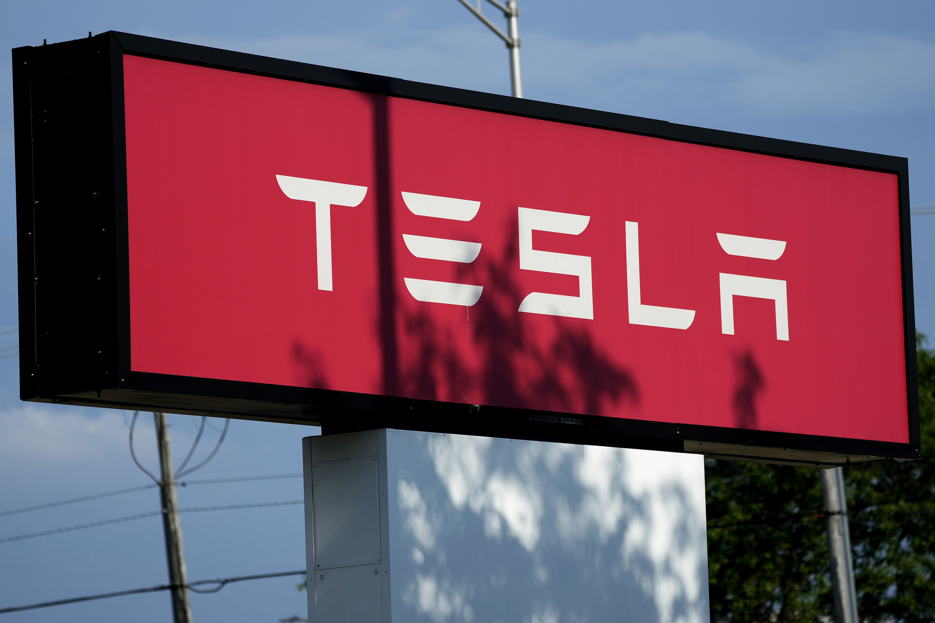 Tesla sign is shown at Tesla dealership in Schaumburg, Ill., Wednesday, July 10, 2024. (AP Photo/Nam Y. Huh)