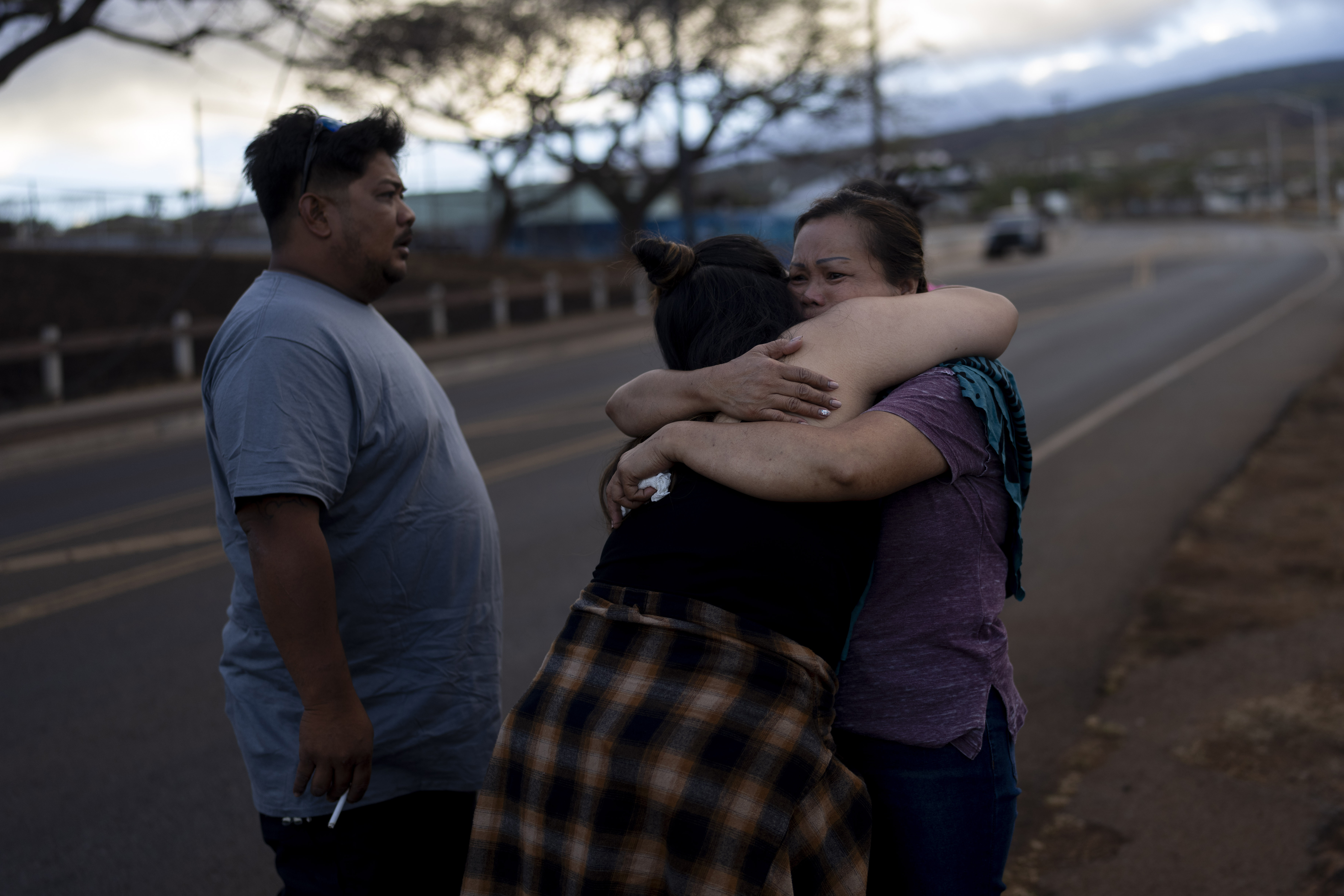 FILE - Nora Bulosan, right, and Hannah Tomas, Lahaina, Hawaii residents who survived the fire that devastated the town, comfort each other as they gather in hopes to get access to their home in Lahaina, Hawaii, Aug. 16, 2023. (AP Photo/Jae C. Hong, File)