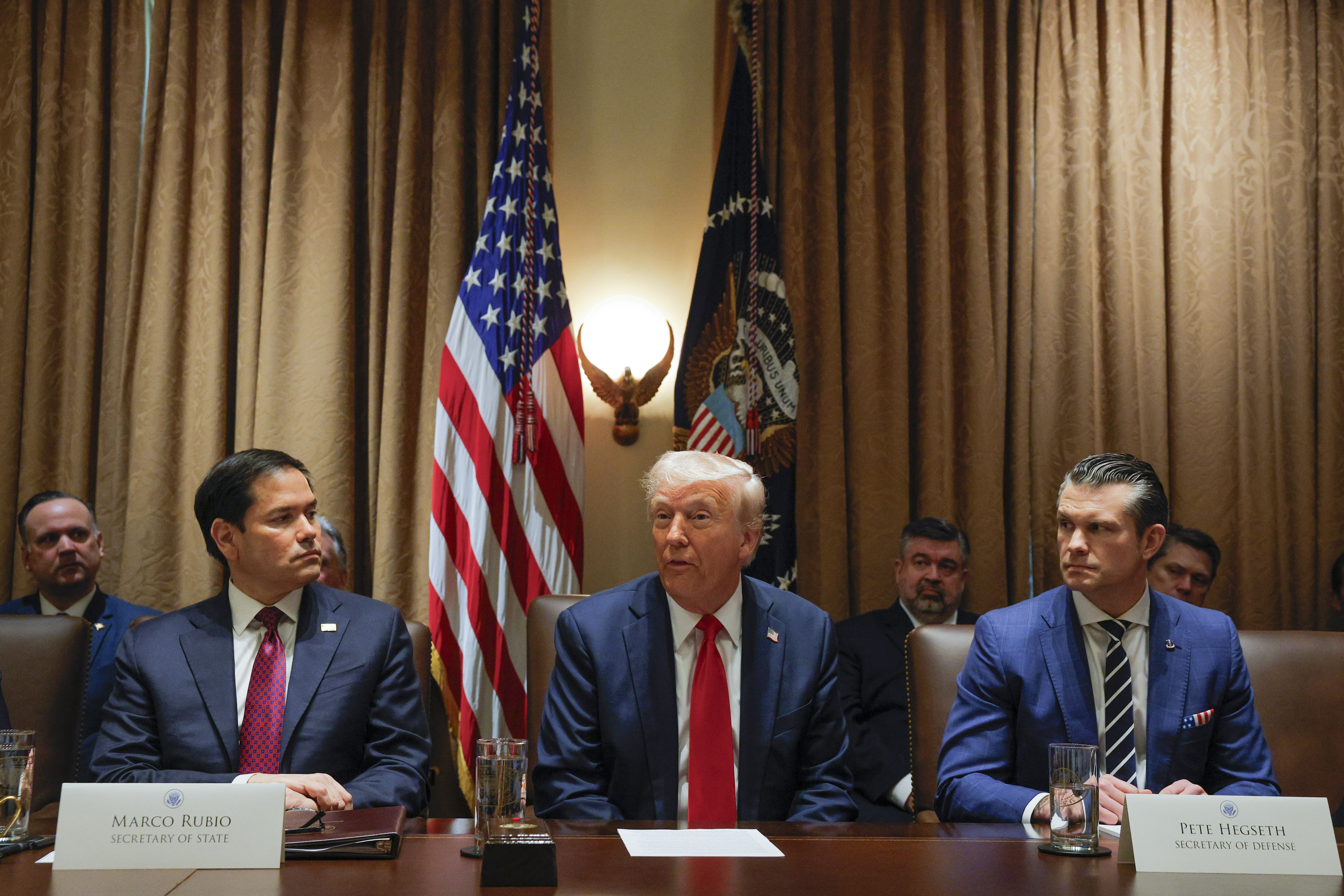 President Donald Trump speaks during a Cabinet meeting at the White House in Washington, Tuesday, Feb. 26, 2025, as Secretary of State Marco Rubio and Defense Secretary Pete Hegseth listen. (Pool via AP)