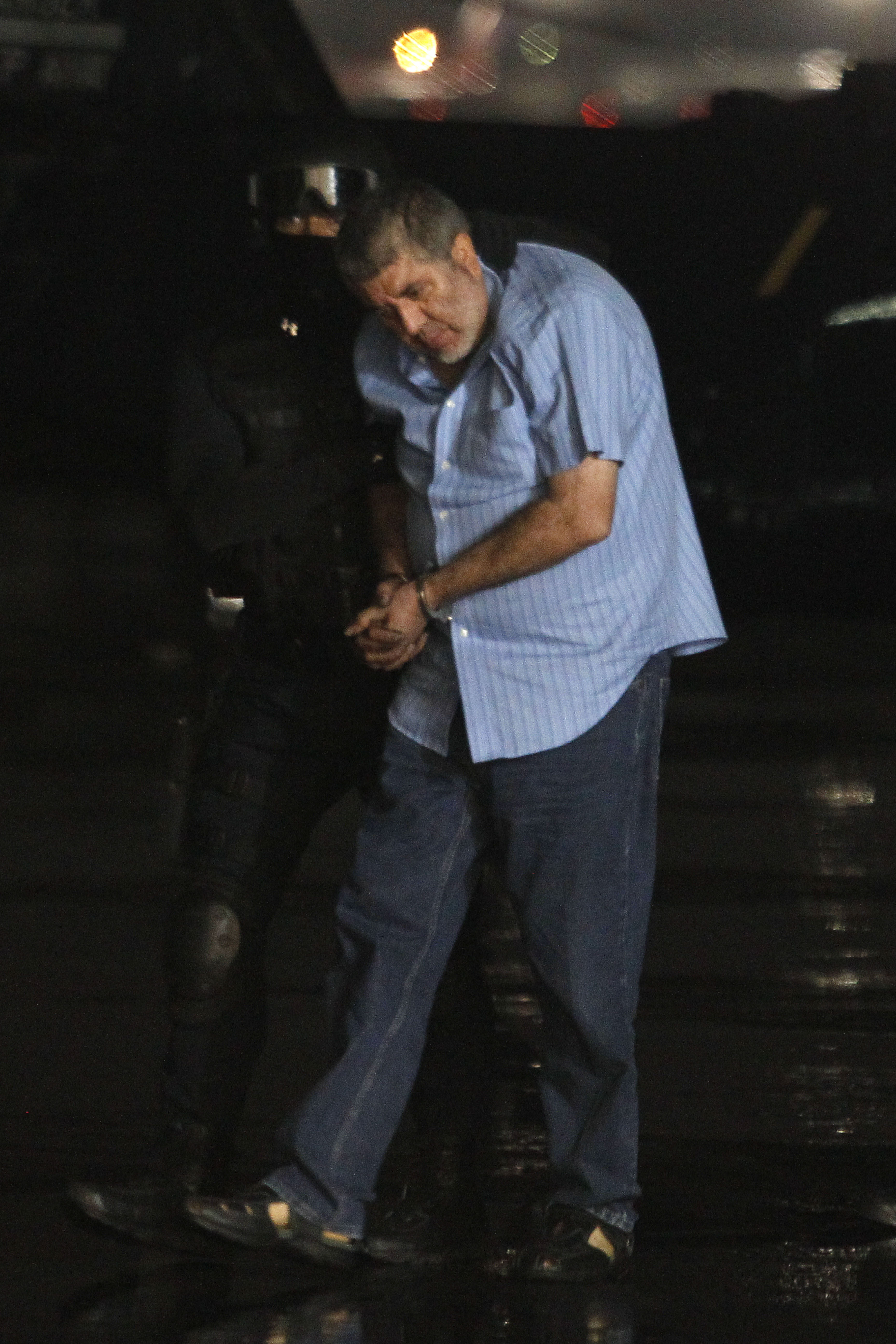 FILE - Vicente Carrillo Fuentes, the purported leader of the Juarez cartel, is led to a helicopter after his arrest at the hangar of the Mexican Attorney Generals Office in Mexico City, Oct. 9, 2014. (AP Photo, File)