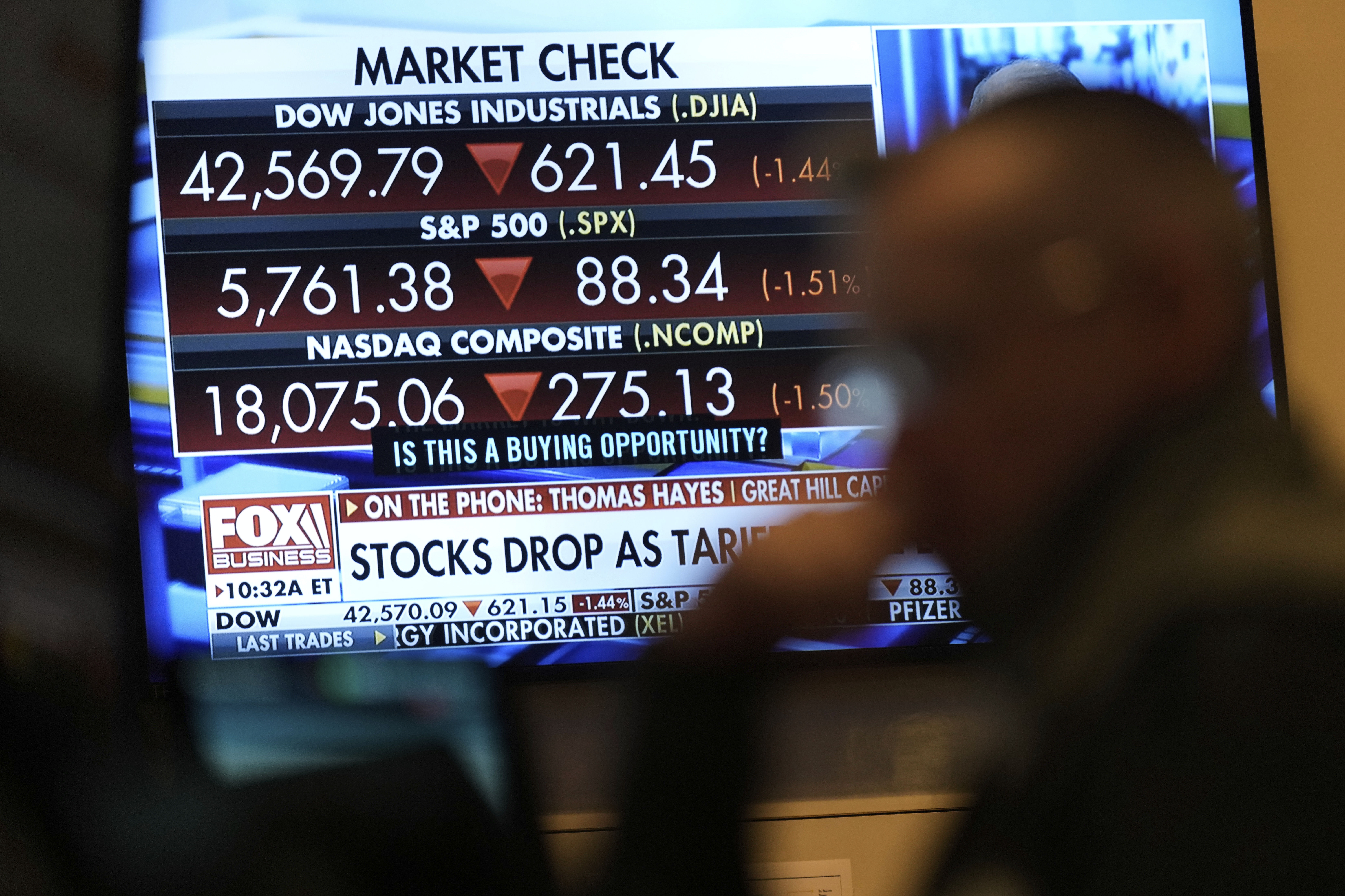 Financial news is displayed as people work on the floor at the New York Stock Exchange in New York, Tuesday, March 4, 2025. (AP Photo/Seth Wenig)