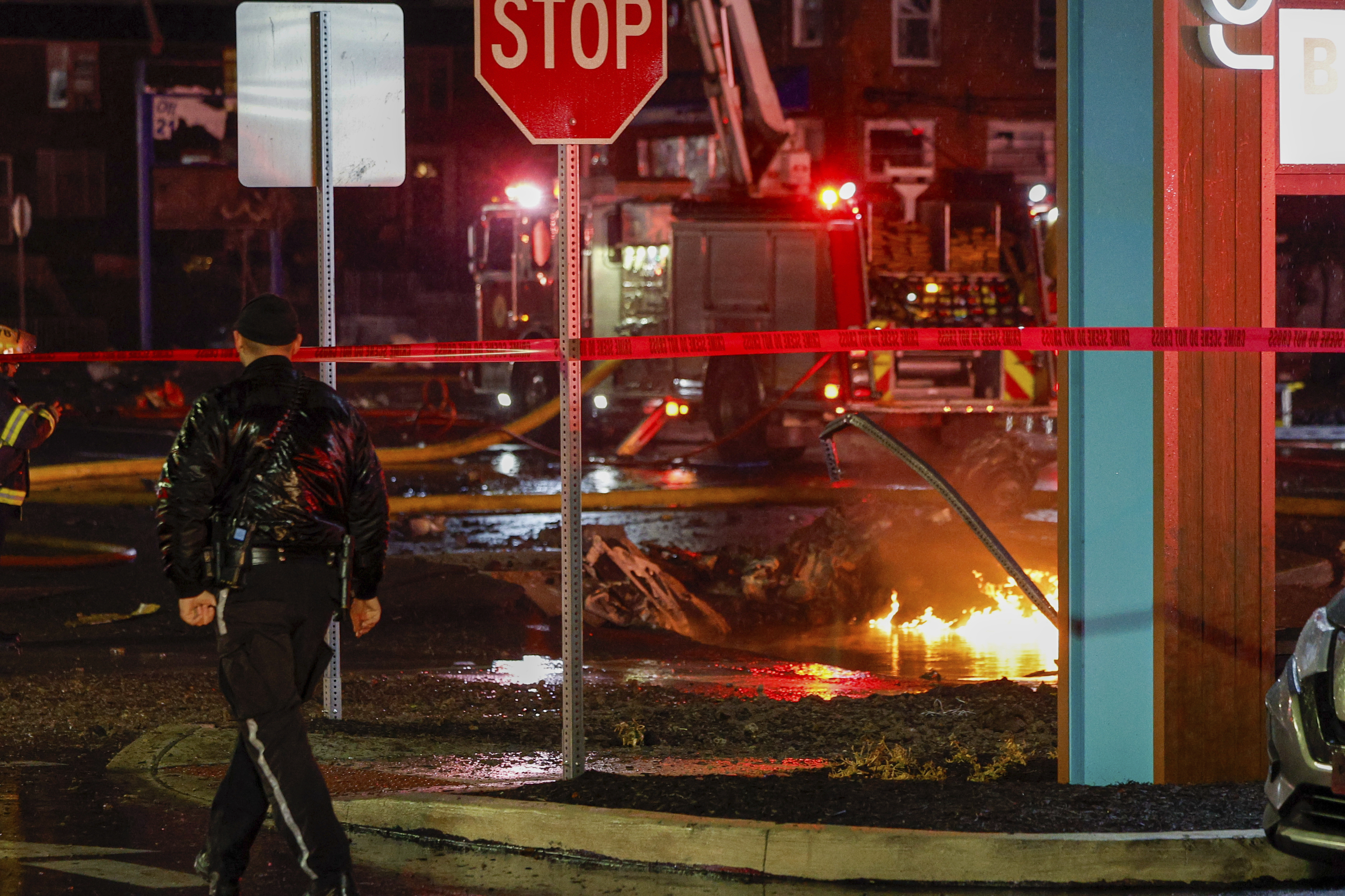 FILE - Fuel burns in the street at Bustleton and Cotton Ave. after a small plane crashed near Roosevelt Mall, Friday, Jan. 31, 2025, in Philadelphia. (Steven M. Falk/The Philadelphia Inquirer via AP, File)