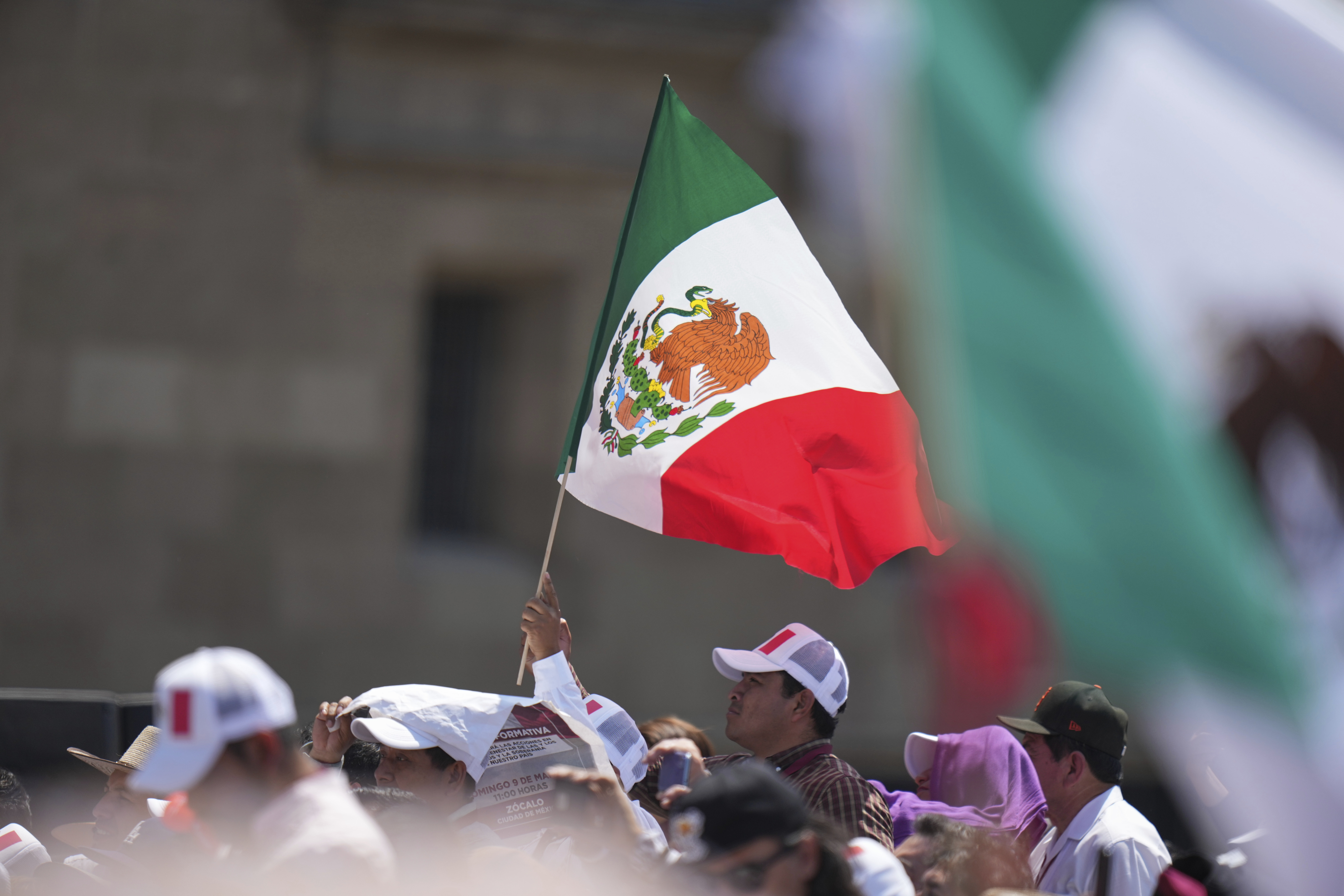 Supporters of President Claudia Sheinbaum attend a rally she convened to welcome U.S. President Donald Trump's decision to postpone tariffs on Mexican goods for one month at the Zocalo, Mexico City's main square, Sunday, March 9, 2025. (AP Photo/Eduardo Verdugo)