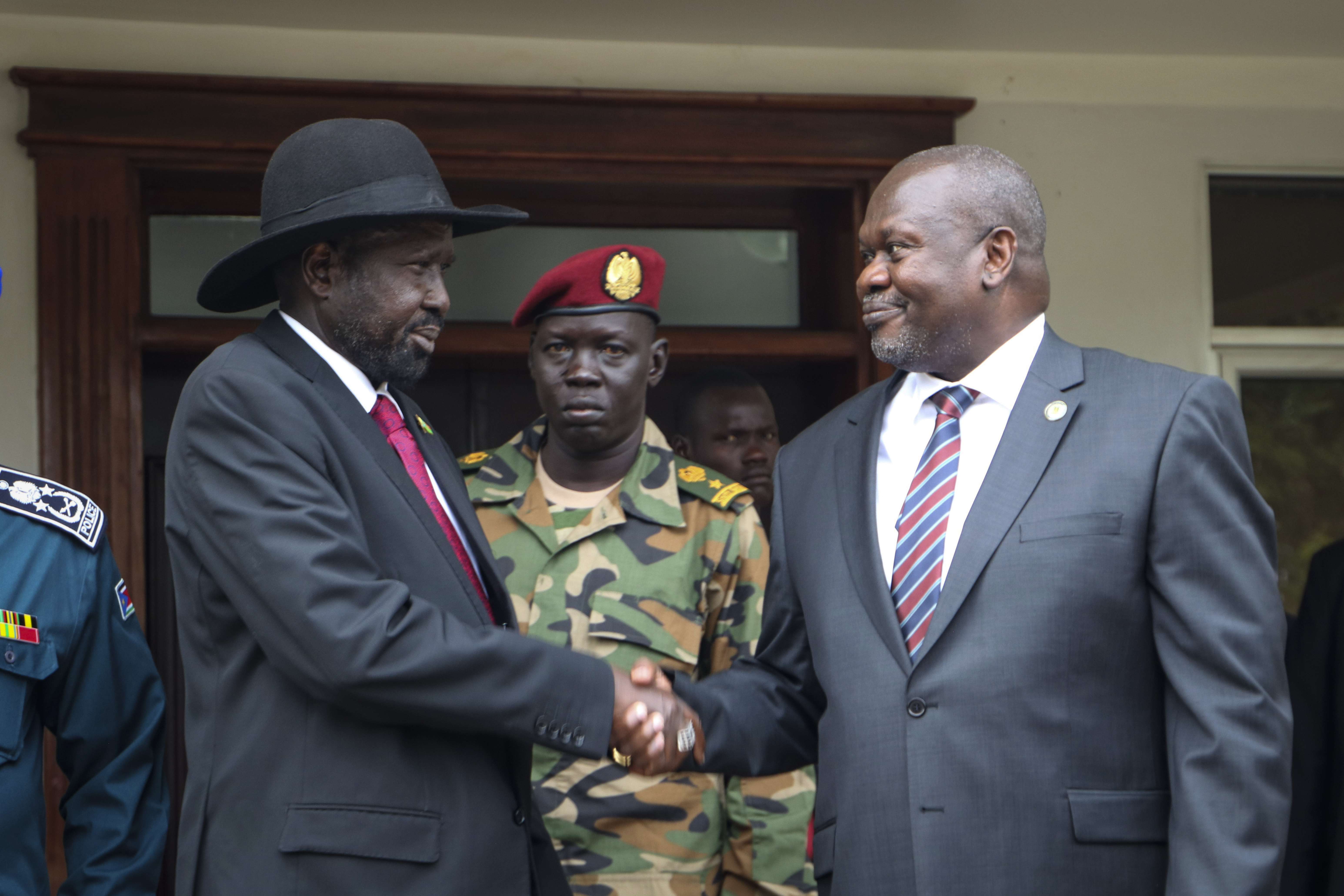 FILE - South Sudan's president Salva Kiir, left, and vice-president Riek Machar, right, shake hands after meetings in Juba, South Sudan, on Oct. 20, 2019, to discuss outstanding issues to the peace deal. (AP Photo/Sam Mednick, File)